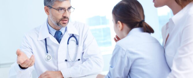 Doctor engaged in a conversation with a mother and her young daughter.