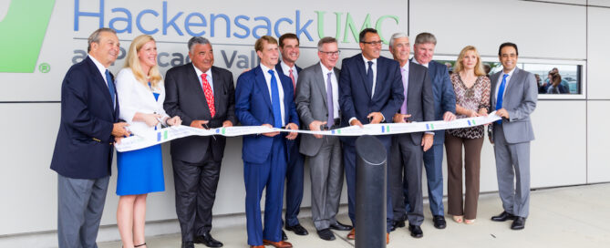 People hold a long ceremonial ribbon stretched across the group at HackensackUMC Pascack Valley.