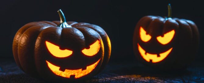 Two carved glowing pumpkins with mischievous face.