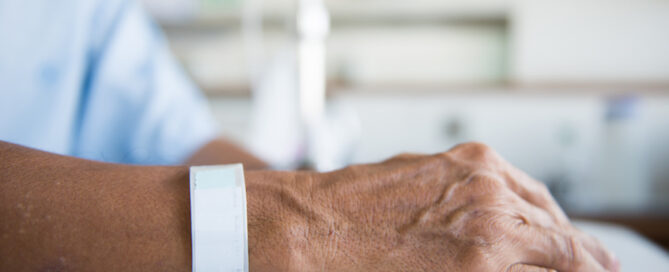 Patient with IV drip and hand tag in a hospital