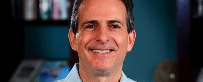 A warm, close-up head-and-shoulders portrait of a middle-aged man filling the frame.