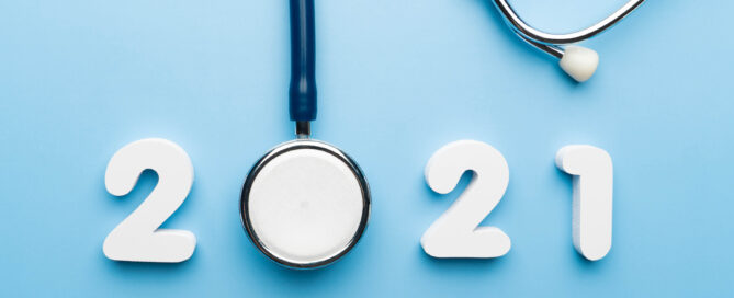 Image in a blue background with numbers "2021" made of white foam or plastic. A stethoscope is positioned next to the numbers.