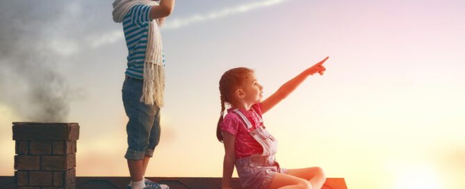 Two kids on the roof looking far away.