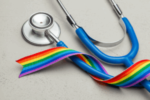 Stethoscope alongside a colorful rainbow ribbon, that represents pride and inclusivity.