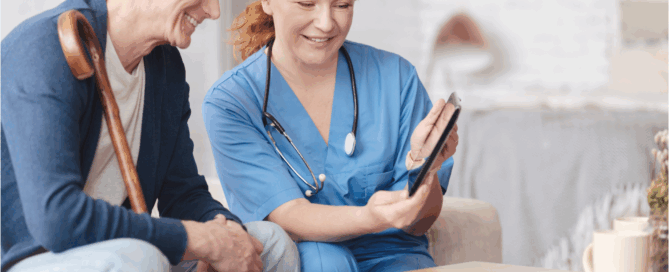 Healthcare professional smiling and interacting with an older man who is seated beside her.