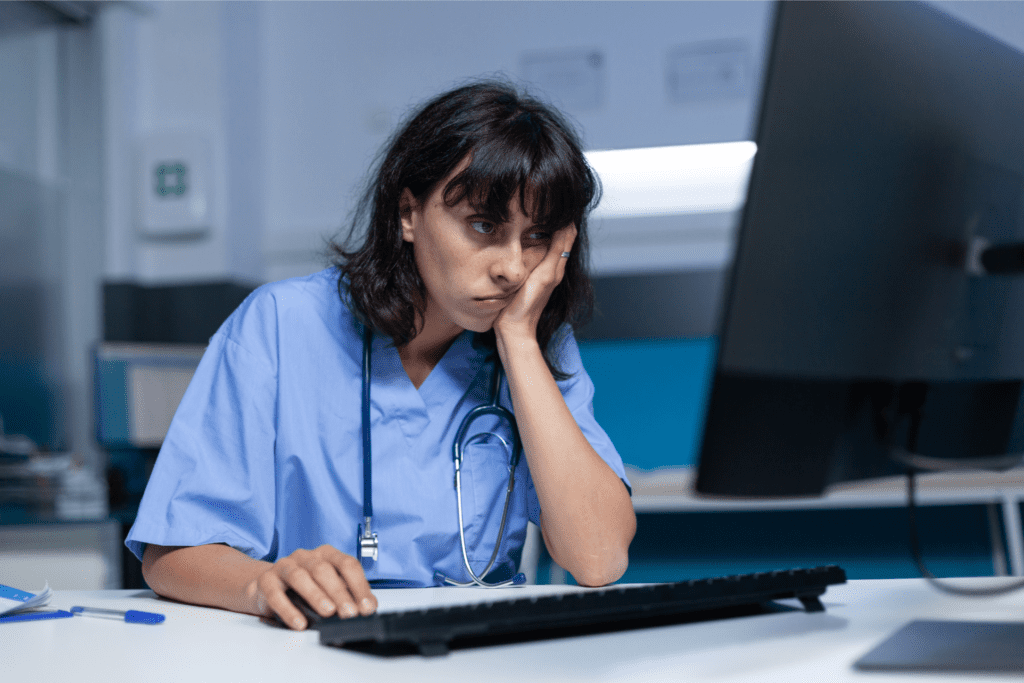 Tired healthcare worker working in front of a computer