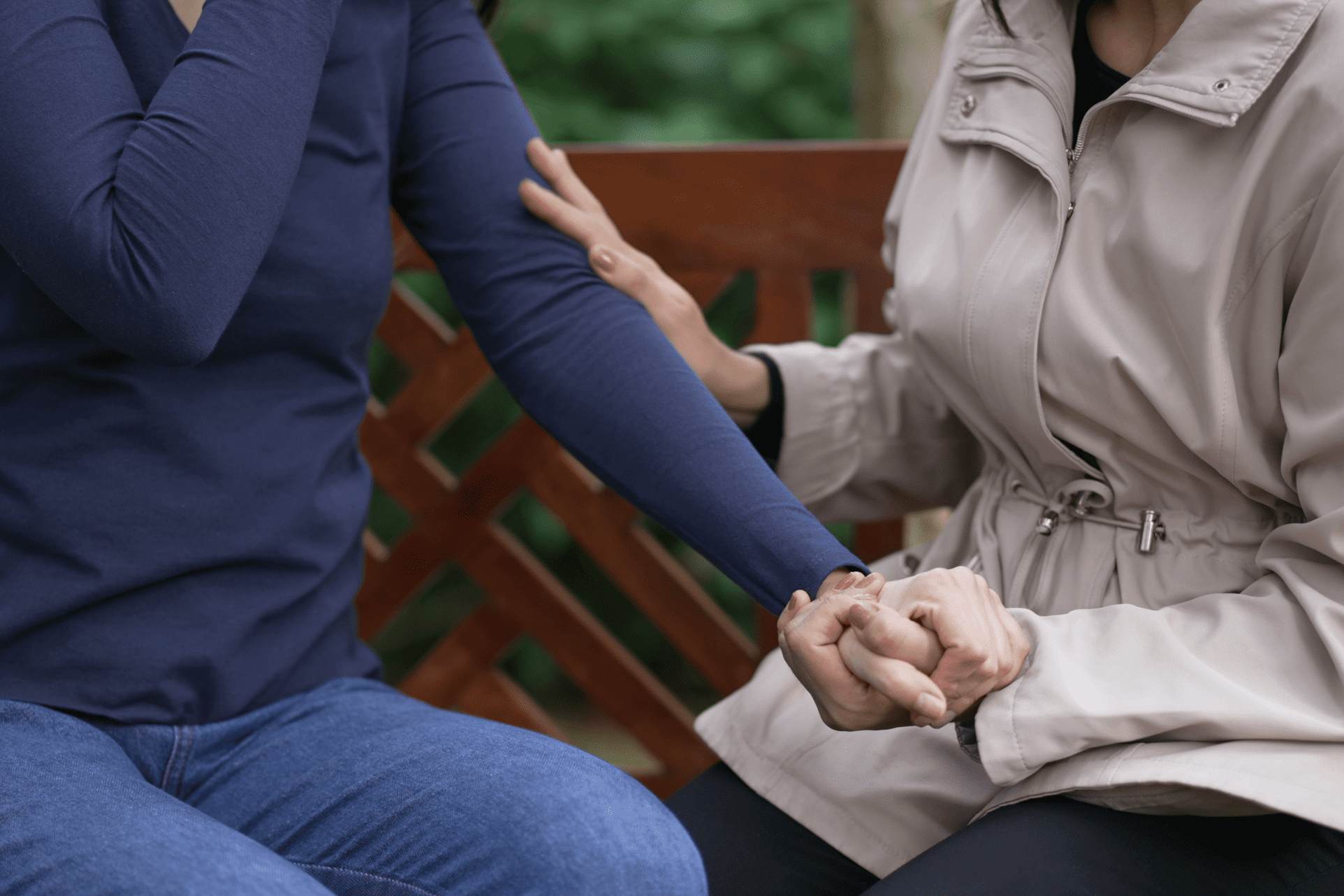 Holding hands while sitting on a park with focus on the hands