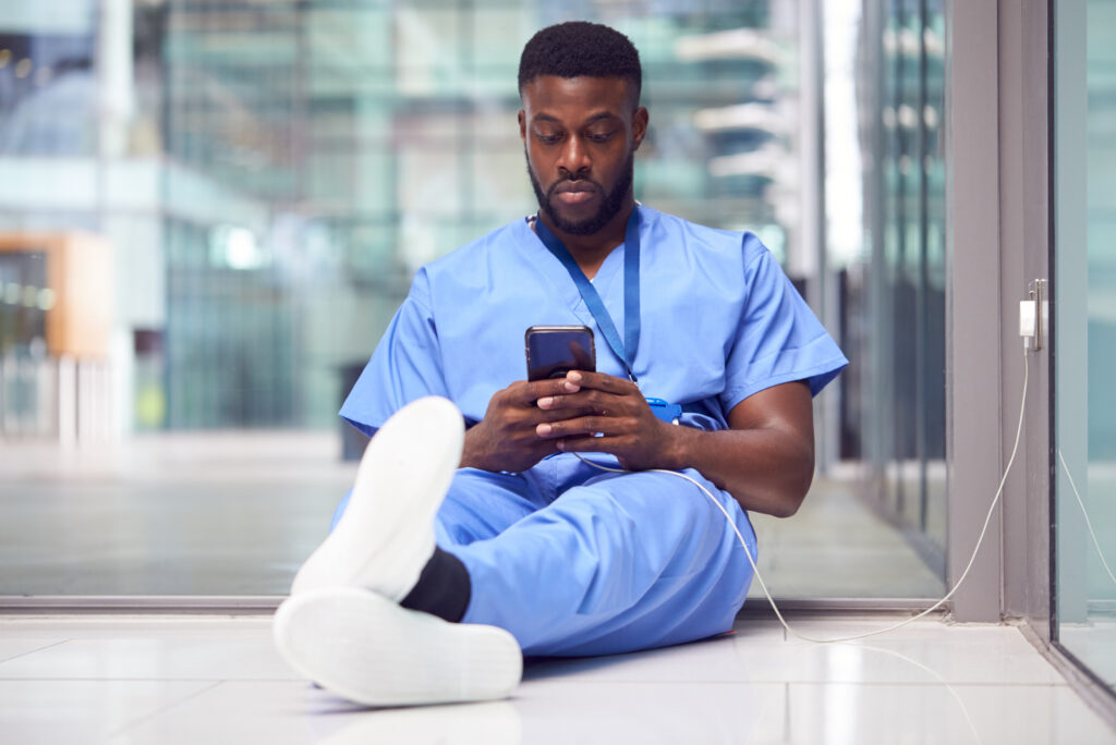 Male Medical Worker In Hospital Addicted To Using Mobile Phone At Work
