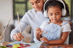 Woman and a young girl are engaged in a painting activity.