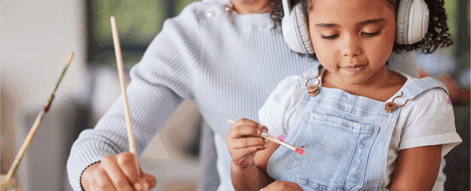 Woman and a young girl are engaged in a painting activity.