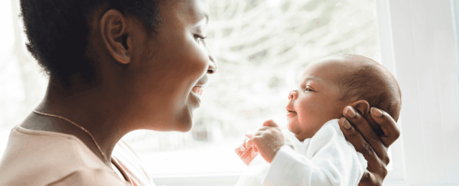 Mother and her newborn baby are facing each other.