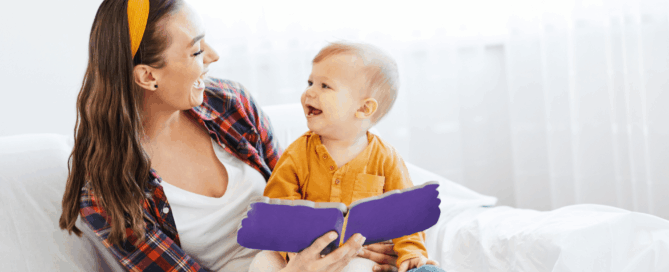 Mother and her young child are sitting together, smiling and looking at each other.