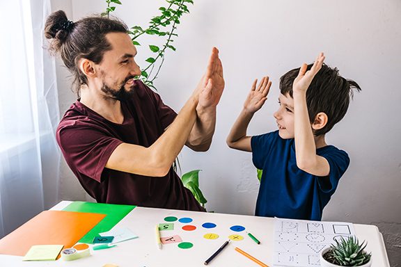 a man and young boy taking a high five a man and young boy taking a high five