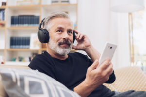 Middle-aged man listening to music online at home.