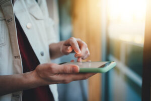 Closeup of female hands using smartphone device browsing.
