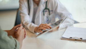 A medical professional using a tablet.