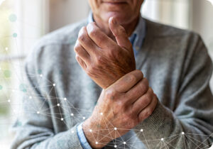 A man holding his wrist while showing signs of discomfort.
