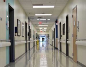 Hospital corridor with patients walking toward an exit