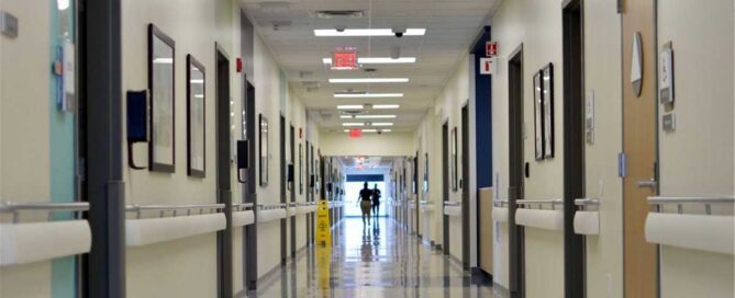 Hospital corridor with patients walking toward an exit