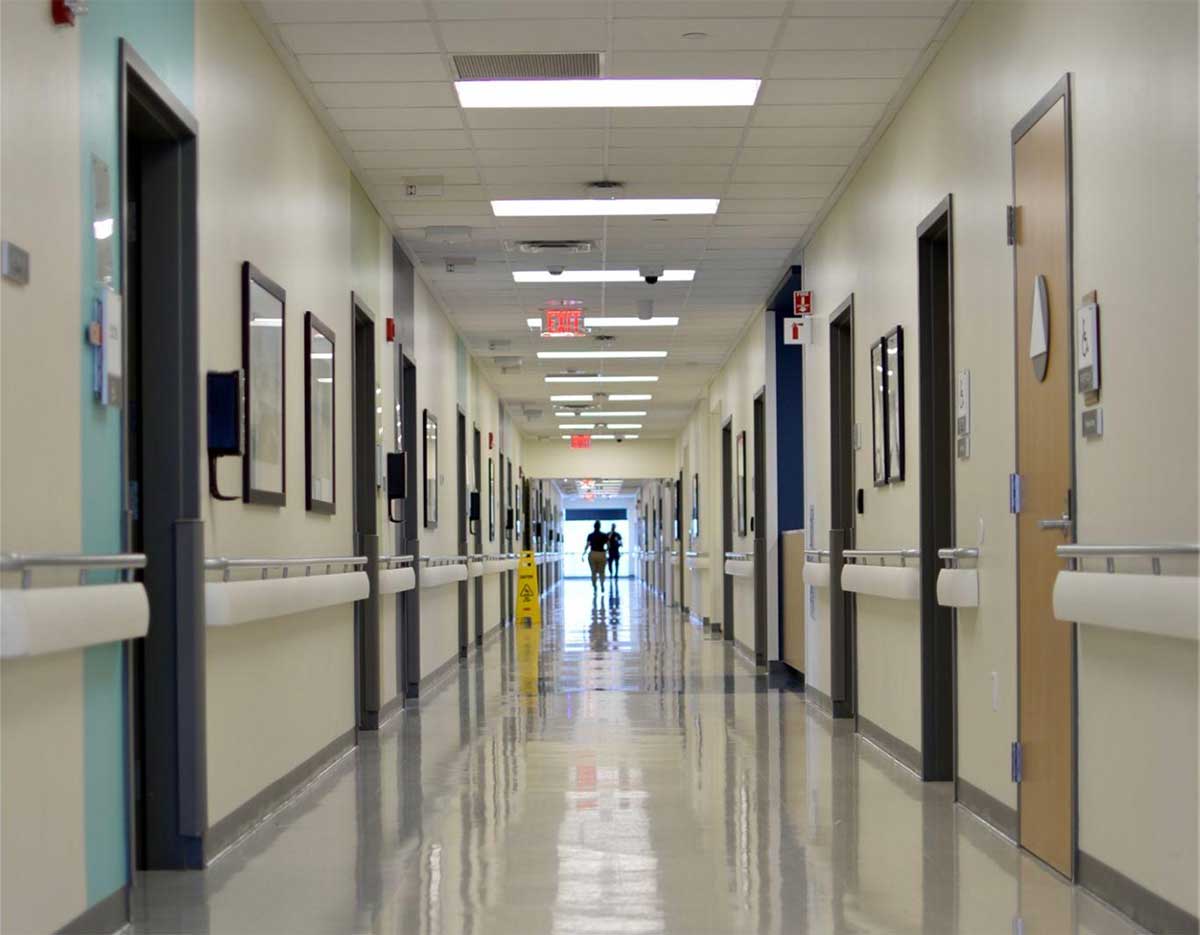 Hospital corridor with patients walking toward an exit