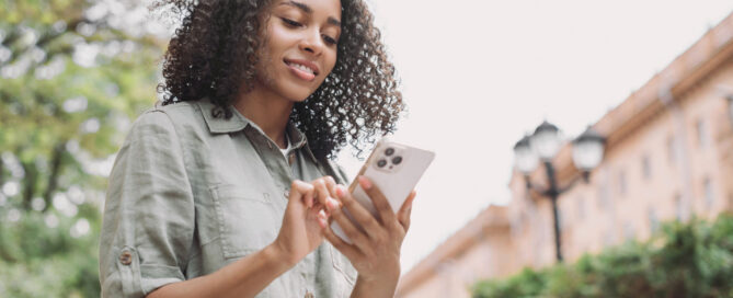 Young woman using mobile phone for patient communication beyond the Patient Portal.